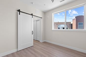 A room with a sliding door and a window showing a building outside.
